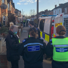 Three police officers stood outside a police van