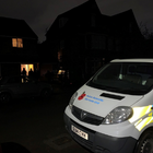 Police van parked outside a house in the dark