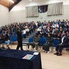 Rows of students sat listening to presenter at youth conference