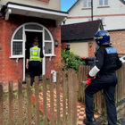 Police officers entering a house