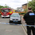 Two police officers stood in front of police tape