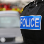 Back of a police vest with fire engine in the distance