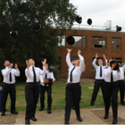 Group of student officers throwing their police hats in the air