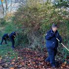 Three officers doing a weapon sweep in a park
