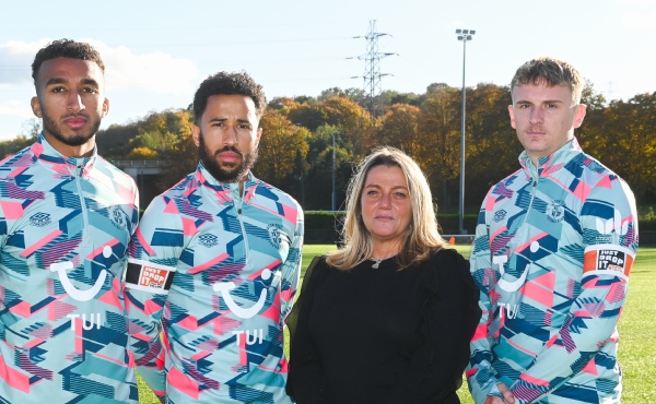 Roseann Taylor standing next to Luton Town players