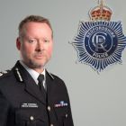 The Chief stood next to Beds Police crest