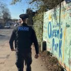 police officer walking through Queens Park
