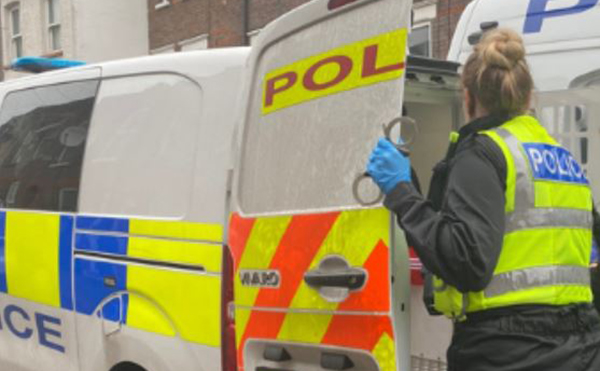 Police officer opening the back of a police van