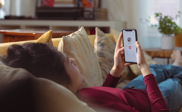Person lying on a sofa holding their mobile phone
